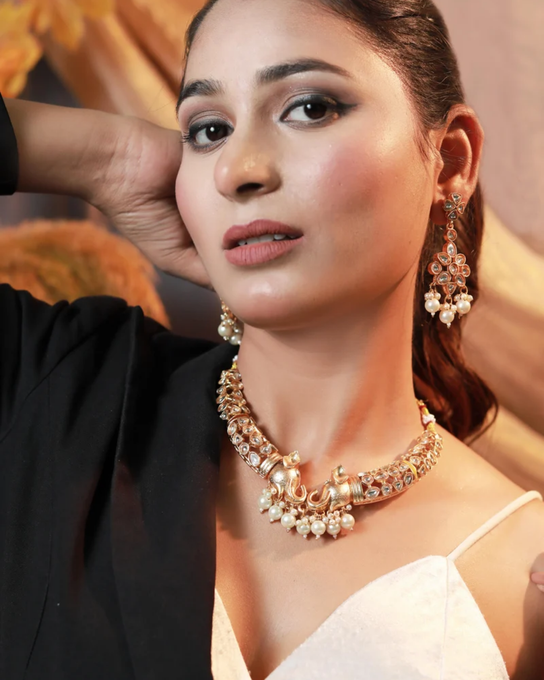 Model wearing a kundan elephant-motif necklace with pearl-drop earrings